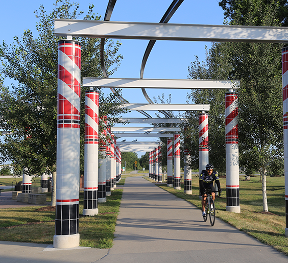 a man riding his bike at the waukee traihead of the racoon river valley trail