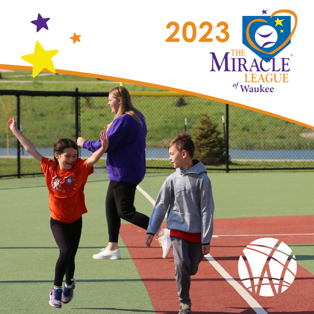 young girl running with hands in the air along next to young boy on baseball field