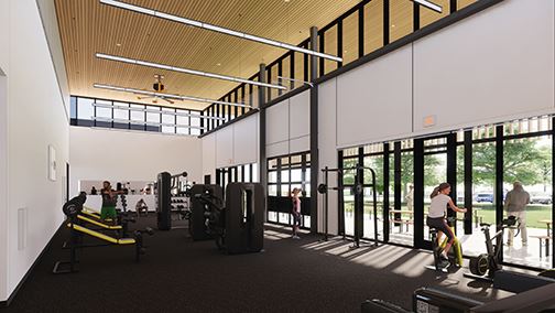 Large room with gym equipment facing wall of windows looking at courtyard