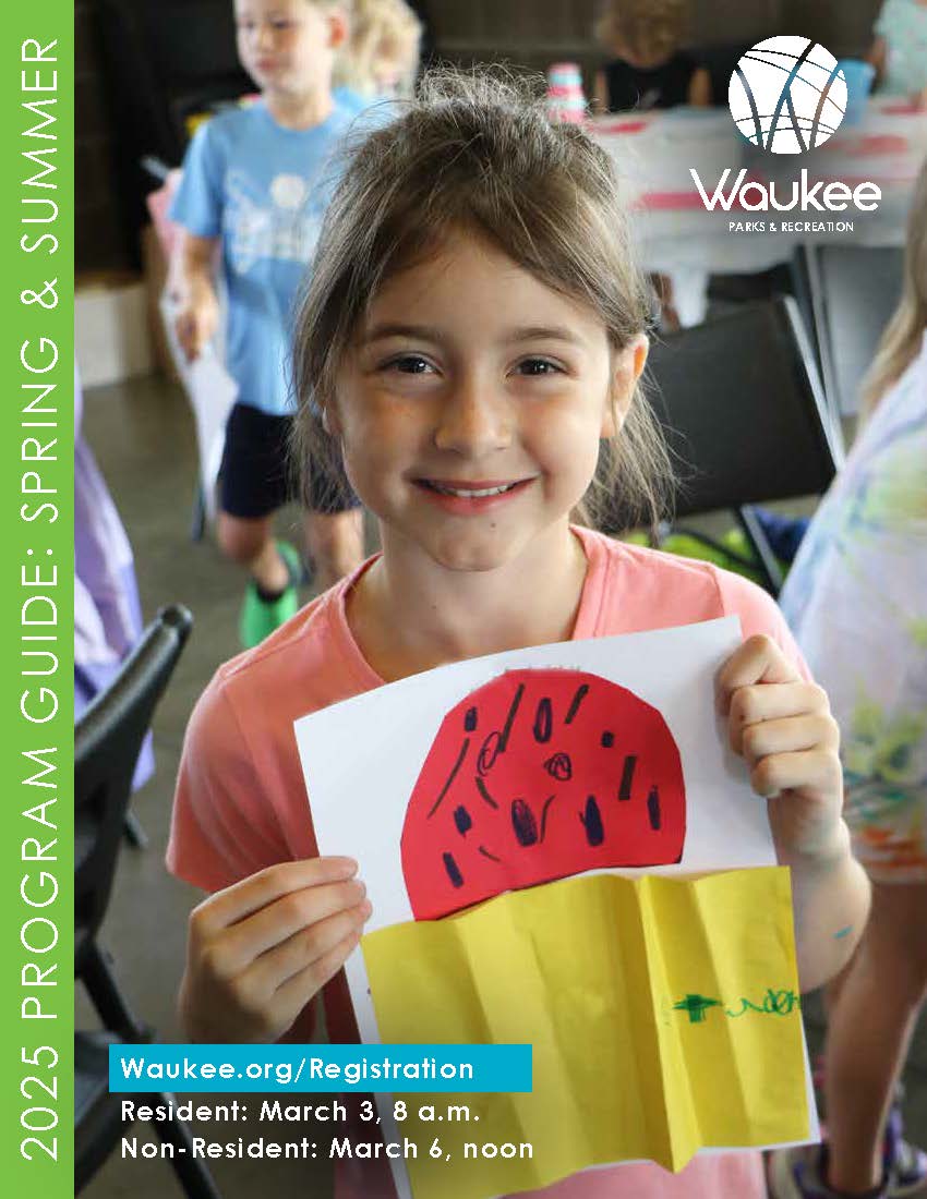 young girl smiling and holding up an art piece she made in summer camp with words Program Guide 2025
